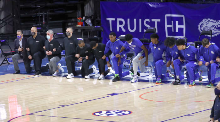 Kentucky Wildcats coaches and players kneel during the national anthem prior to a game against the Florida Gators on Jan. 9, 2021.